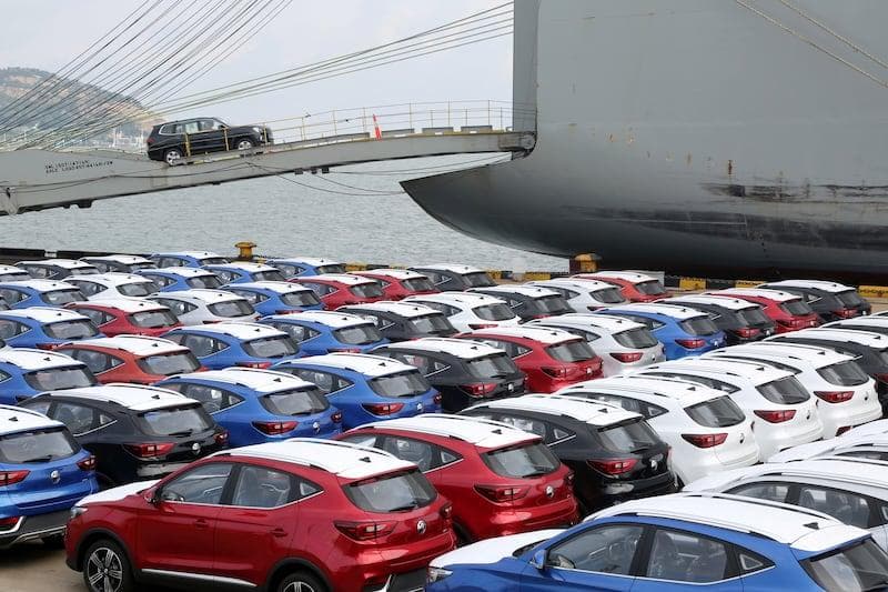 SUVs being loaded onto a cargo ship at port