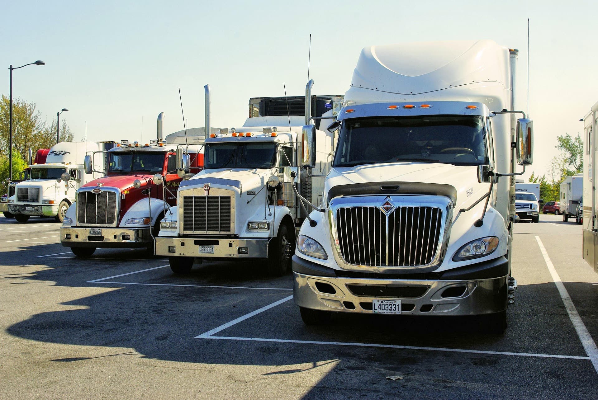 Row of heavy semi-trucks in a freight yard
